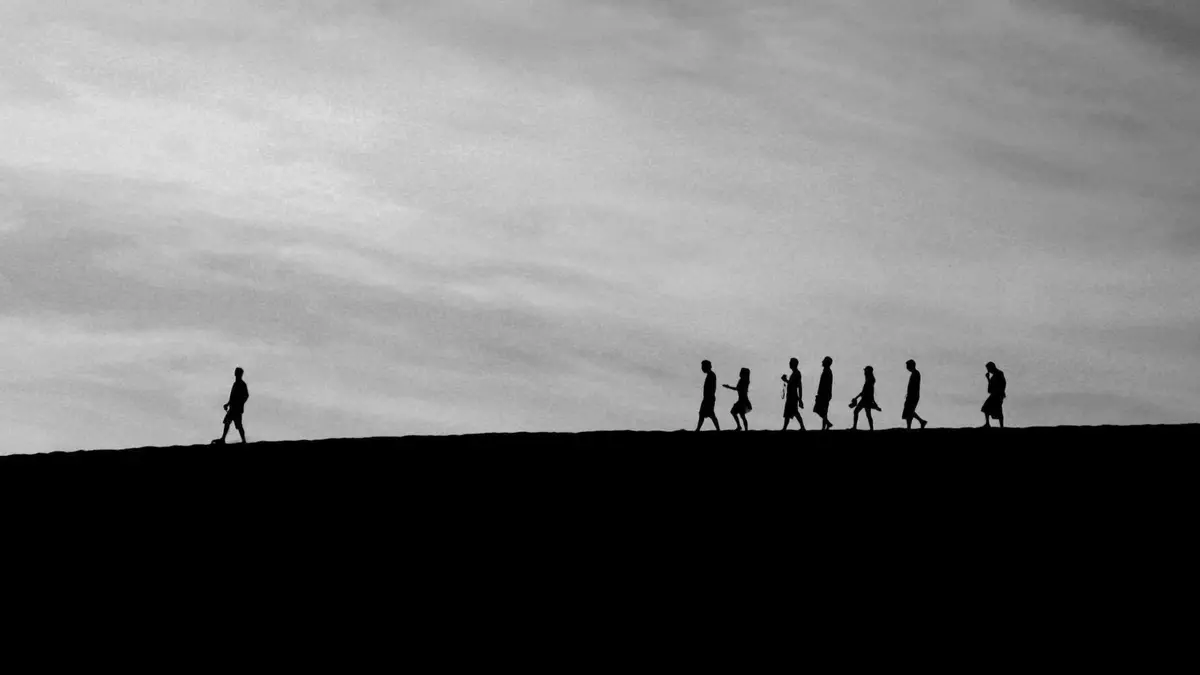 Foto: Unsplash|Jehyun Sung Silhouetten von Menschen. Ein Mensch geht in eine Richtung, viele weitere gehen als Gruppe dahinter.