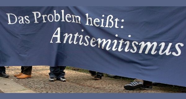 zum Dossier (Flagge mit der Aufschrift: "Das Problem heißt Antisemitismus". Foto: picture-alliance / ZB | Peter Endig)
